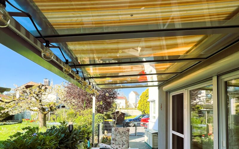 seitliche Terrasse mit Glasdach und Beschattung