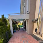 seitliche Terrasse mit Glasdach und Beschattung