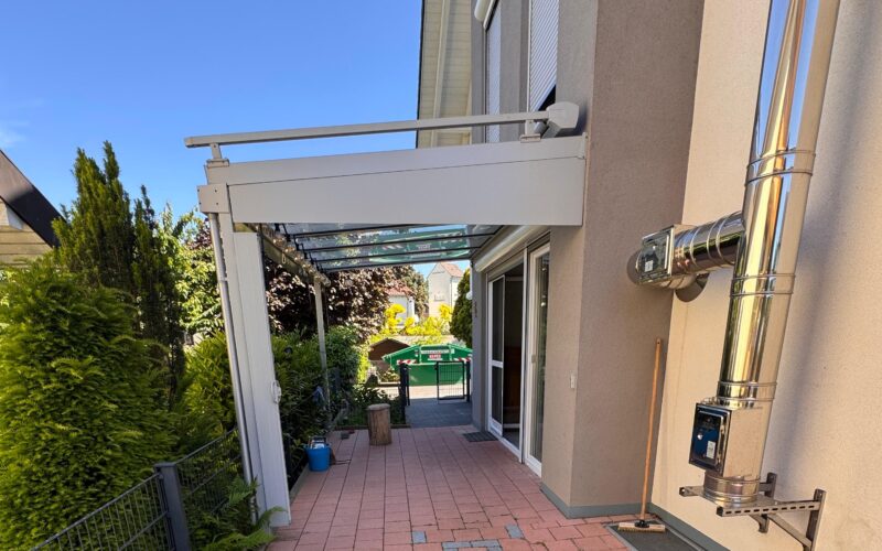 seitliche Terrasse mit Glasdach und Beschattung